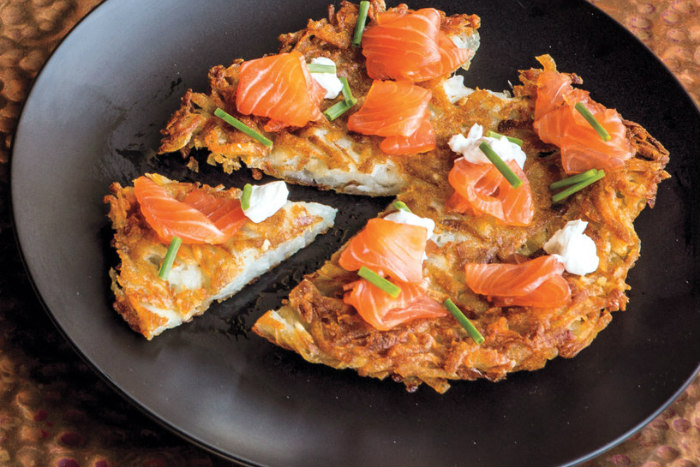 Latkes with gravlax on a black plate